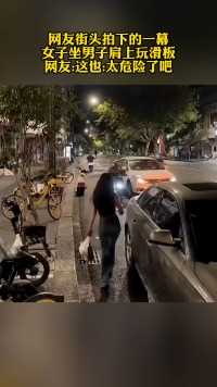 网友街头拍下的一幕女子坐男子肩上玩滑板网友:这也:太危险了吧
